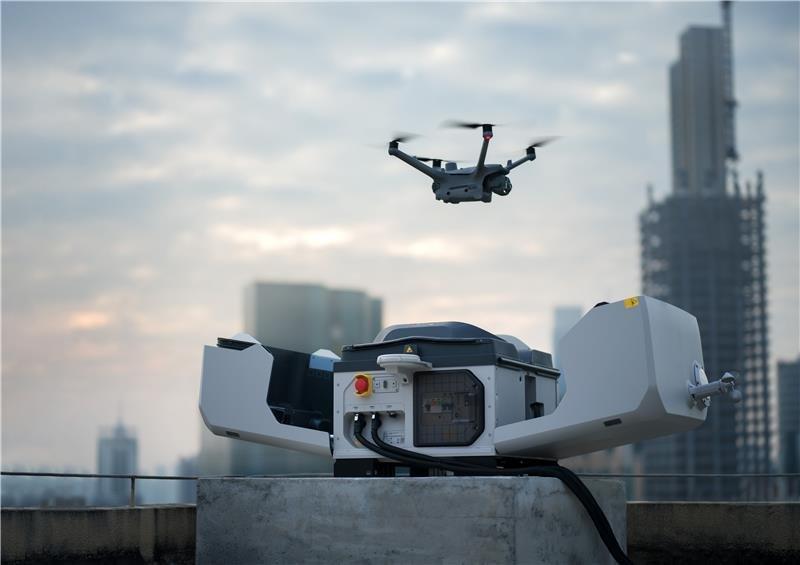 a drone flying over a city with a large building in the background